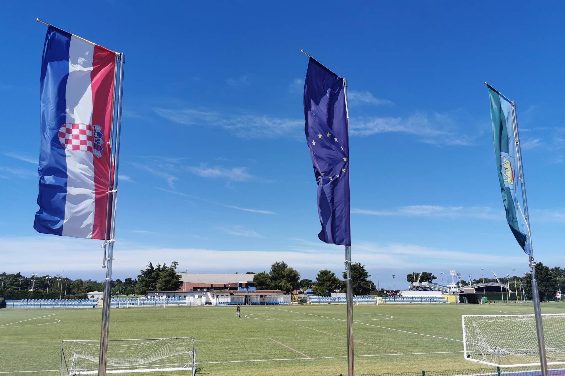 Die Flaggen Kroatiens, der EU und der Stadt Umag wehen über dem Turniergelände Stella Maris, dem Austragungsort des Jugendturniers Adria-dream Cup in Kroatien